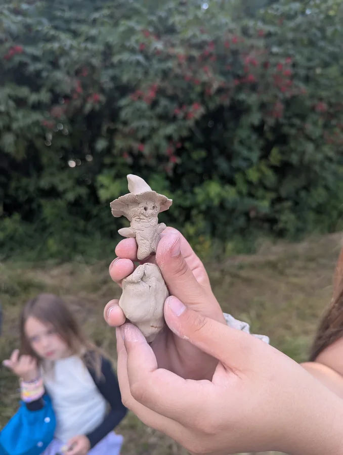Niewielka gliniana postać trzymana w dłoniach podczas plenerowego działania „Bo muzyka jest wokół nas”.