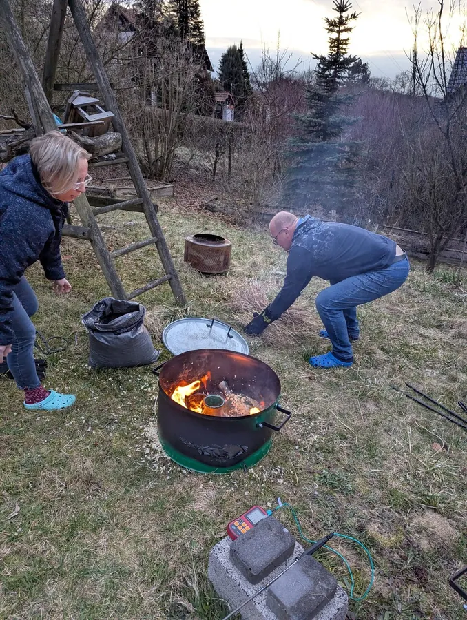 Praca przy redukcji ceramiki podczas testowego wypału plenerowego.